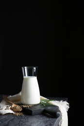 Photo of Composition with hemp milk on table against black background