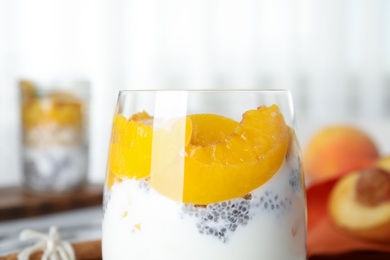 Tasty peach dessert with yogurt and chia seeds on table, closeup