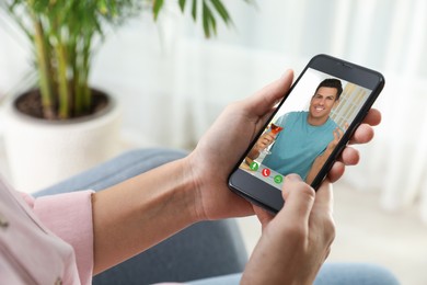 Image of Woman talking with handsome man using video chat on smartphone indoors, closeup. Online dating