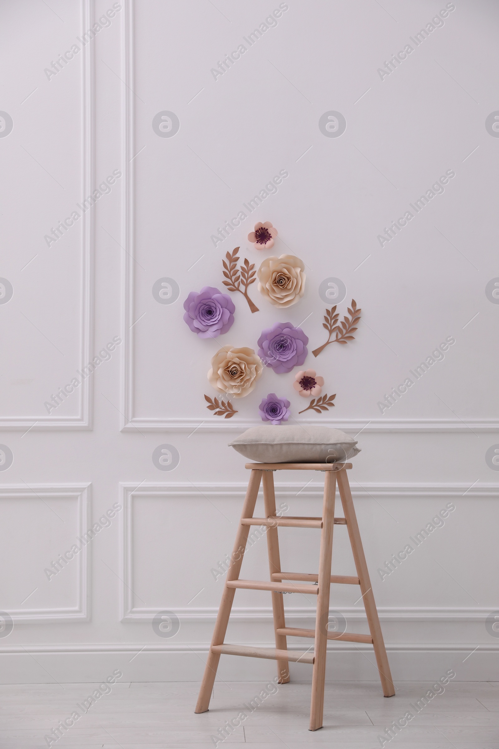 Photo of Stylish room interior with floral decor and wooden stand
