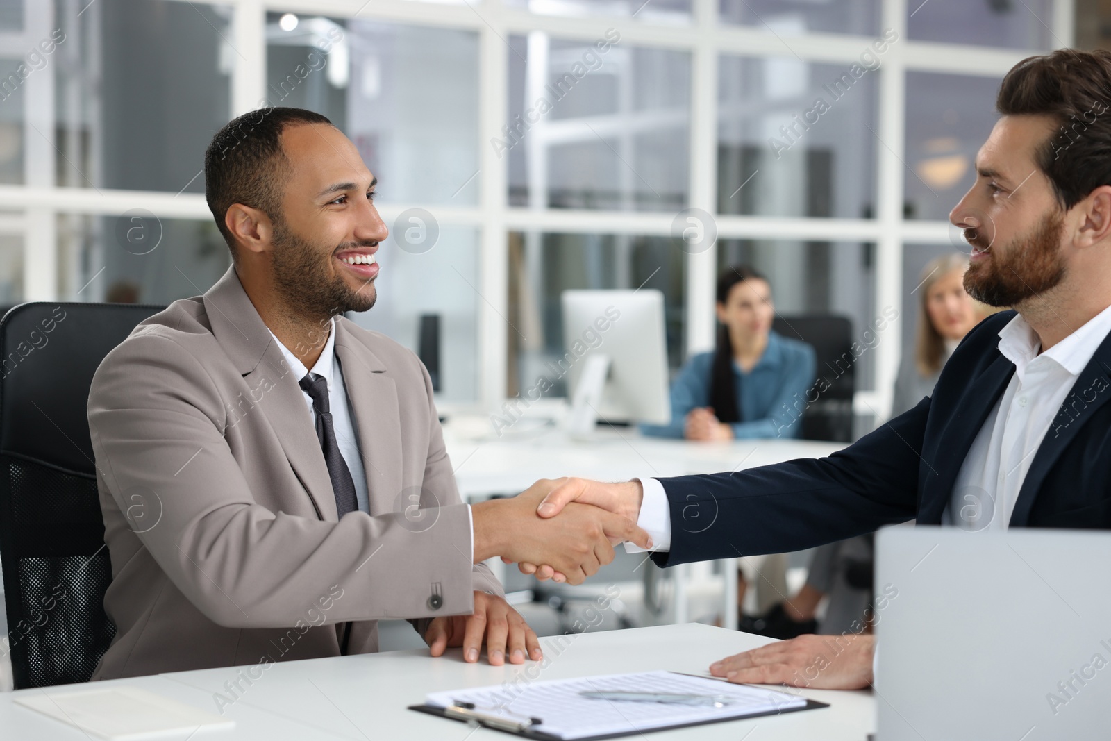 Photo of Lawyer shaking hands with client in office, selective focus