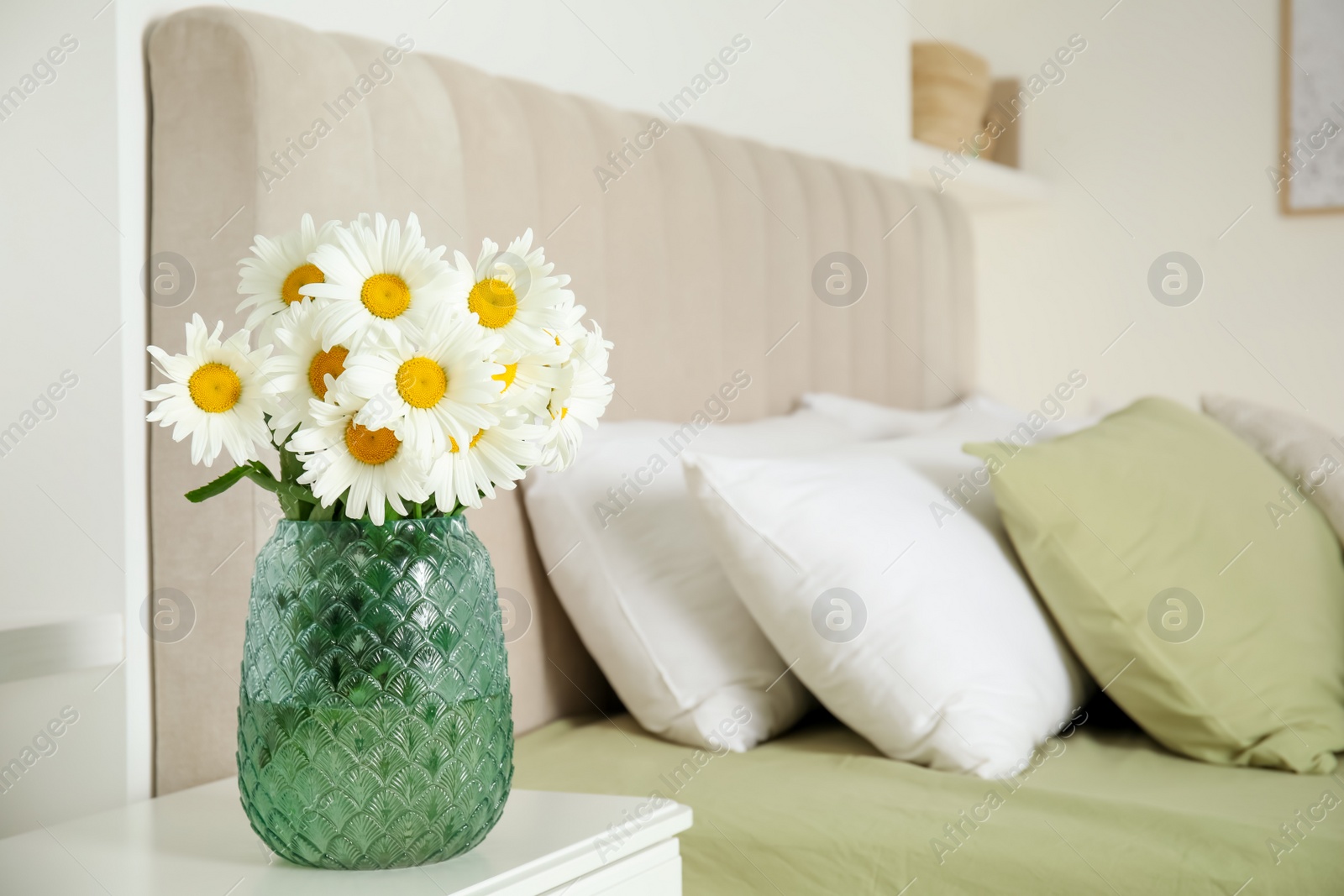Photo of Bouquet of beautiful daisy flowers on nightstand in bedroom, space for text