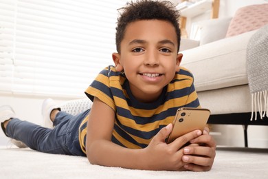 Photo of Cute African-American boy playing on phone at home