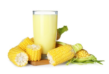 Photo of Tasty fresh corn milk in glass and cobs on white background