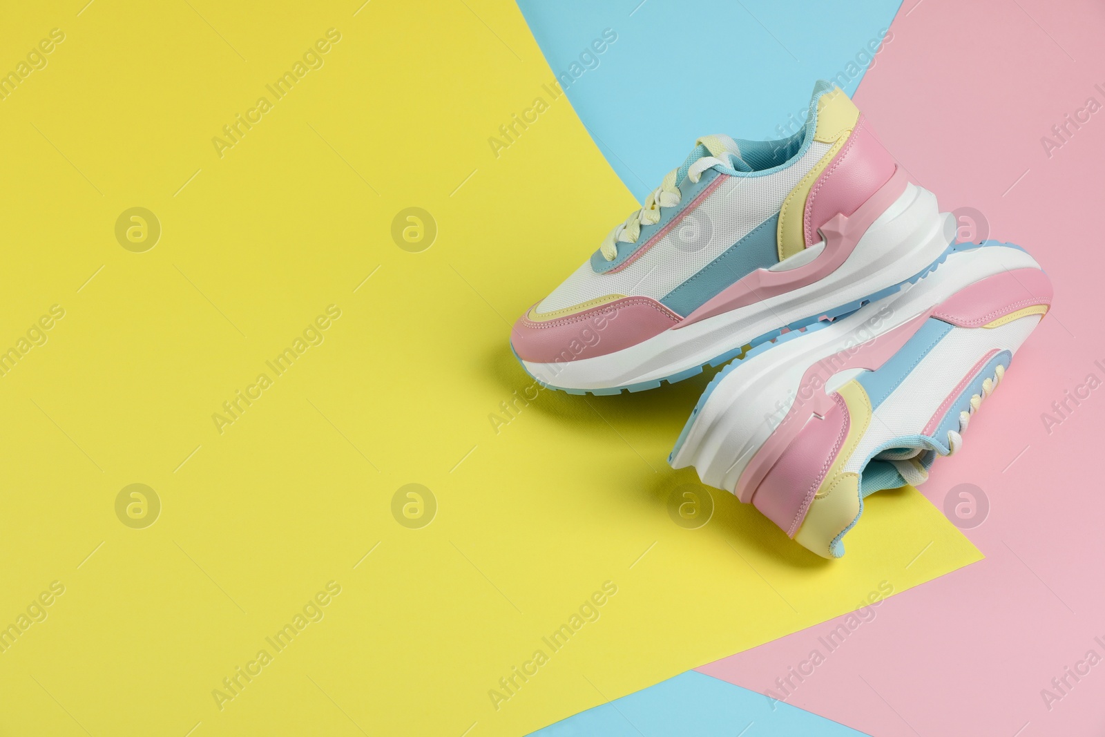 Photo of Pair of stylish bright sneakers on color background, space for text