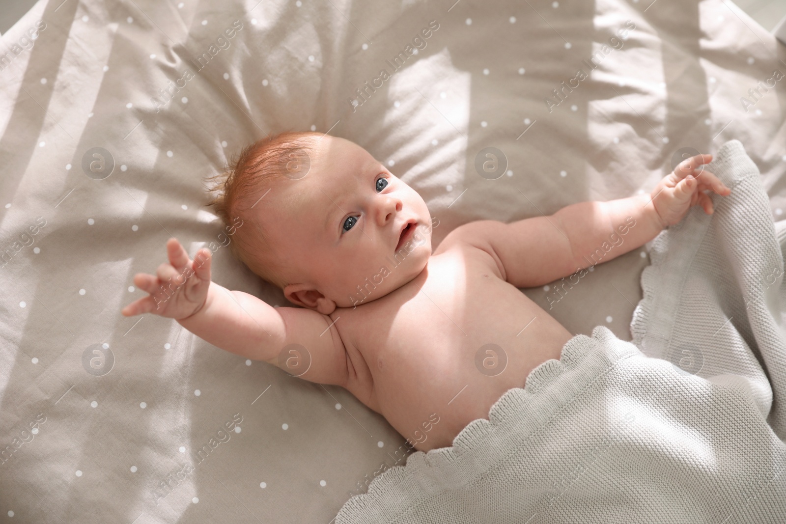 Photo of Cute little child lying in cot, above view. Healthy baby