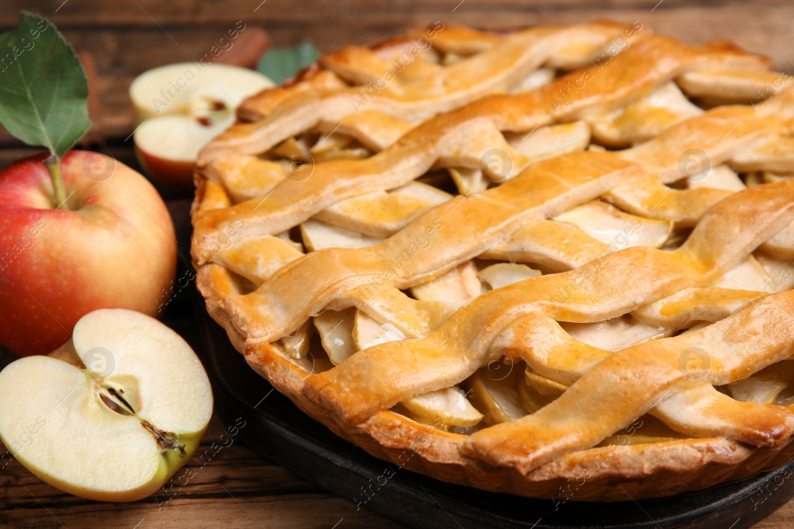 Photo of Delicious traditional apple pie on wooden table, closeup