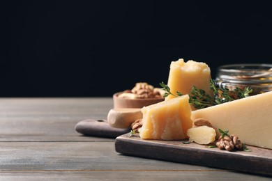 Photo of Delicious parmesan cheese served with honey, walnuts and thyme on wooden table. Space for text