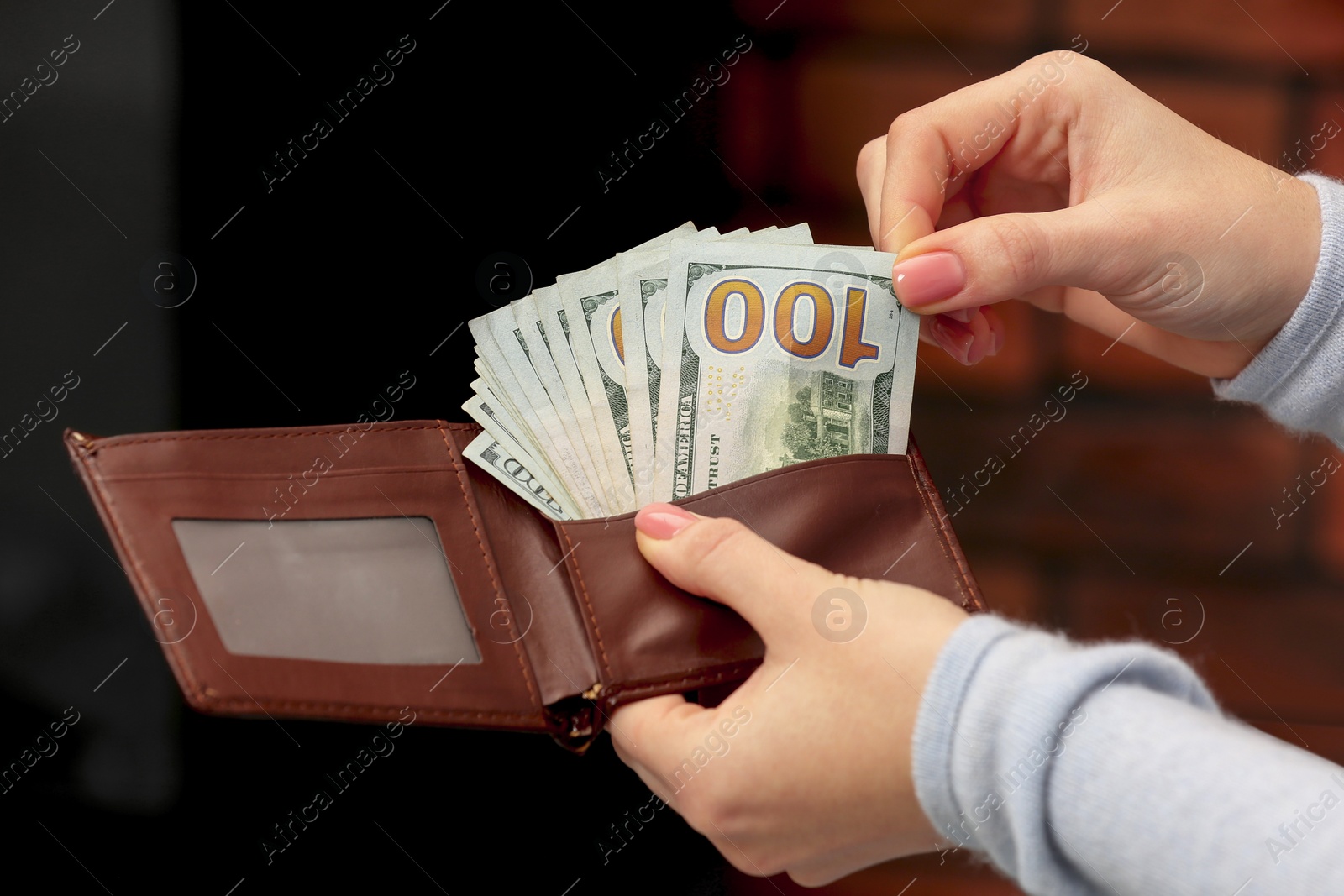 Photo of Woman counting dollar bills indoors, closeup. Money exchange