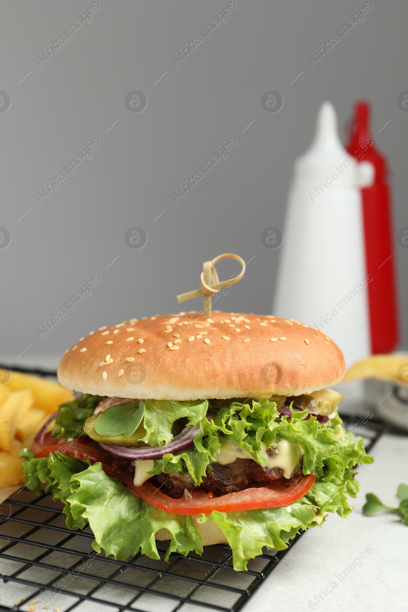 Photo of Delicious burger with beef patty and lettuce on white table
