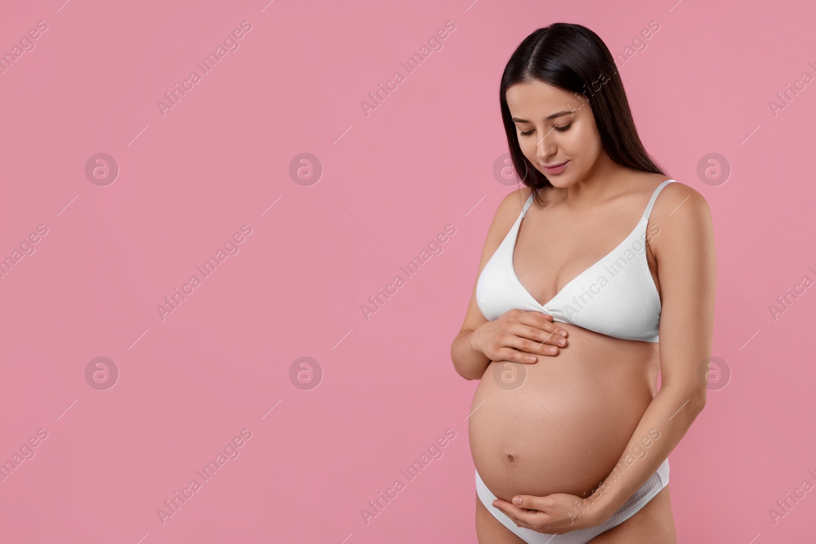 Photo of Beautiful pregnant woman in stylish comfortable underwear on pink background, space for text