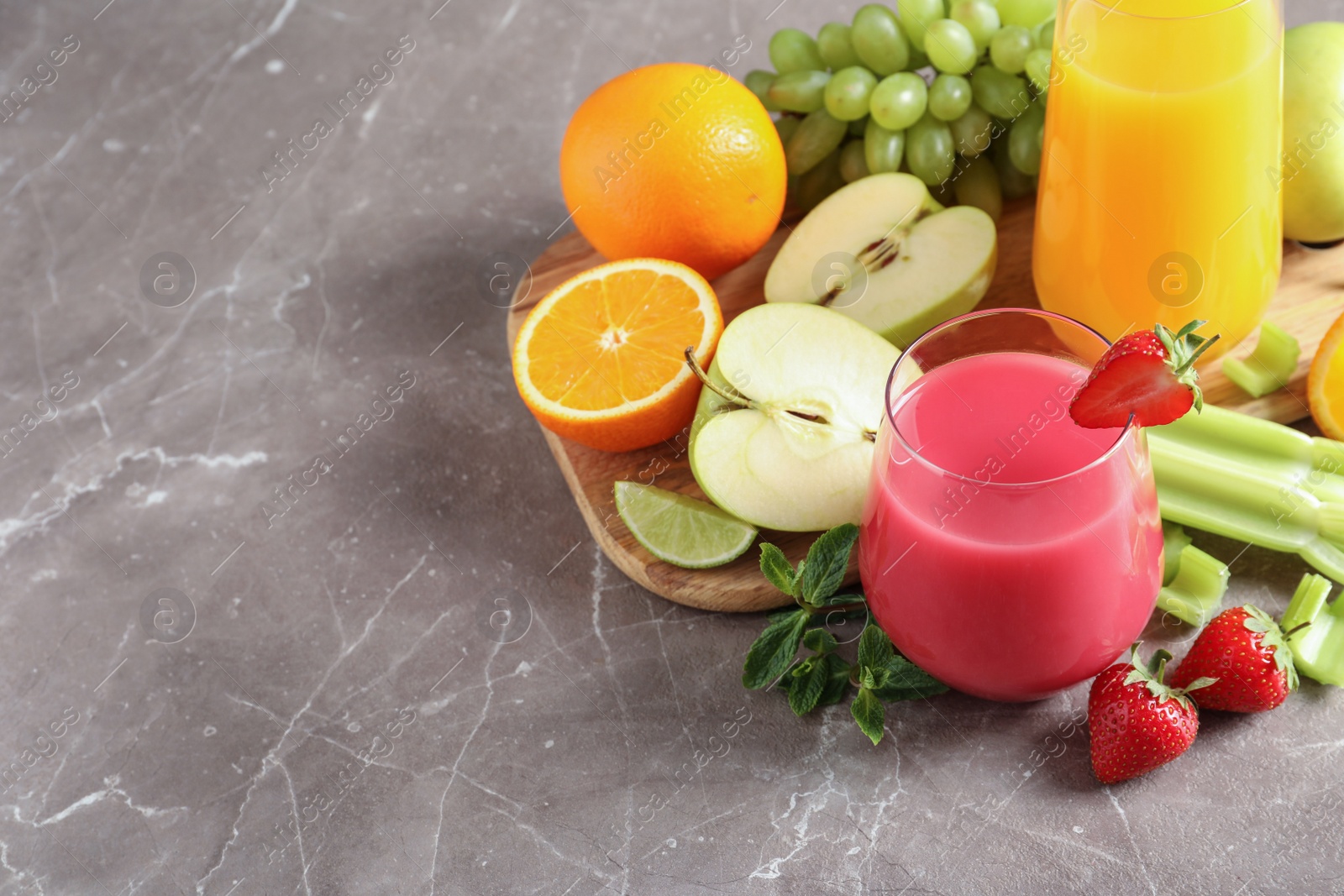 Photo of Glasses with different juices and fresh fruits on table. Space for text