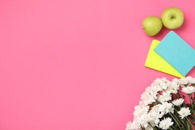 White chrysanthemum flowers, notebooks and apples on pink background, flat lay with space for text. Teacher's day