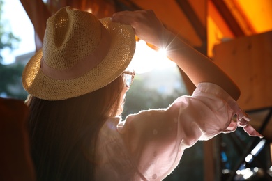 Woman wearing straw hat resting in outdoor cafe, back view