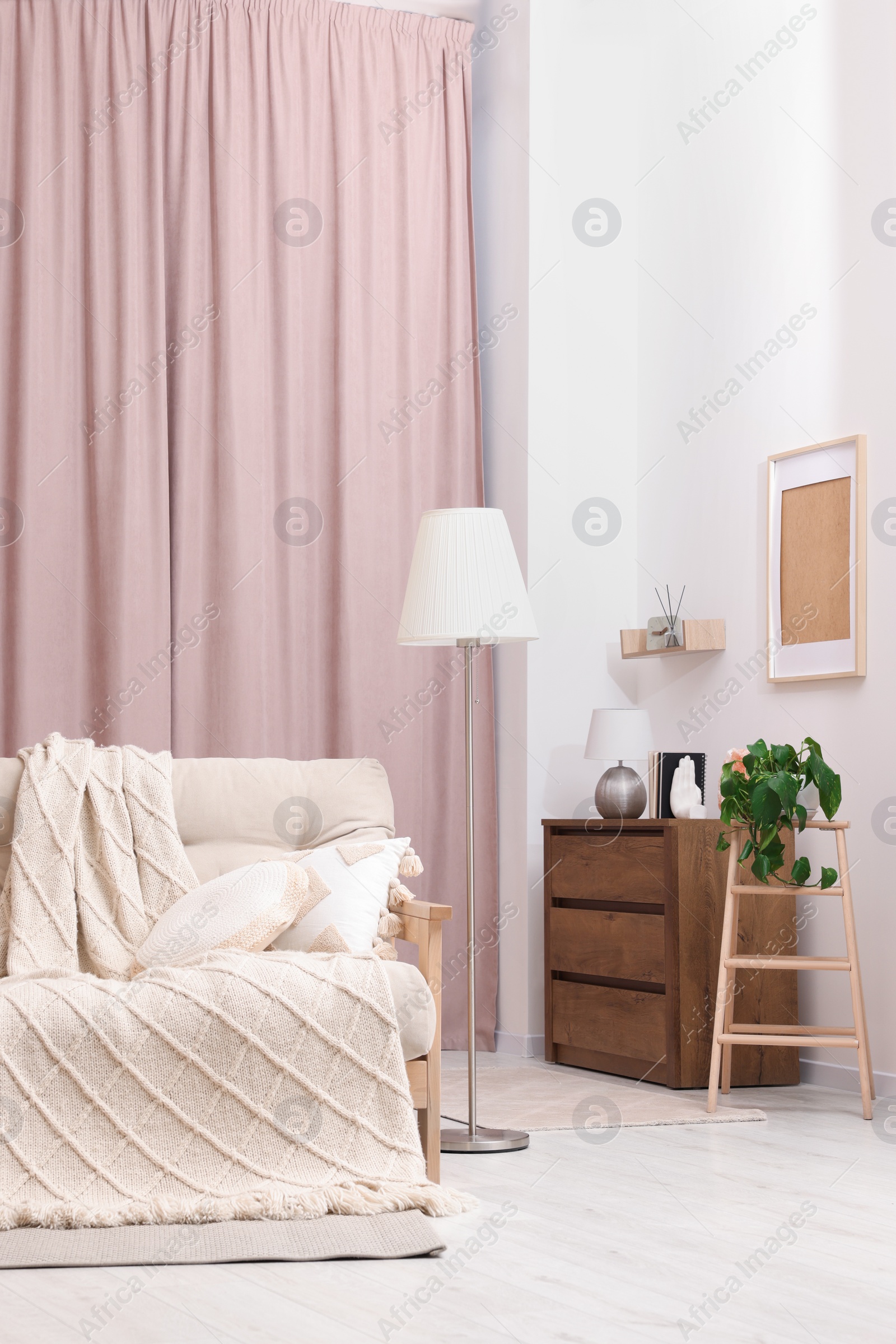 Photo of Comfortable sofa, cushions and blanket in cozy room. Interior design