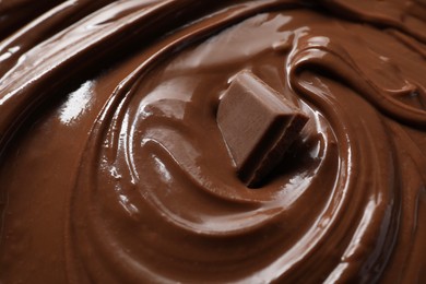 Tasty milk chocolate paste and piece as background, closeup