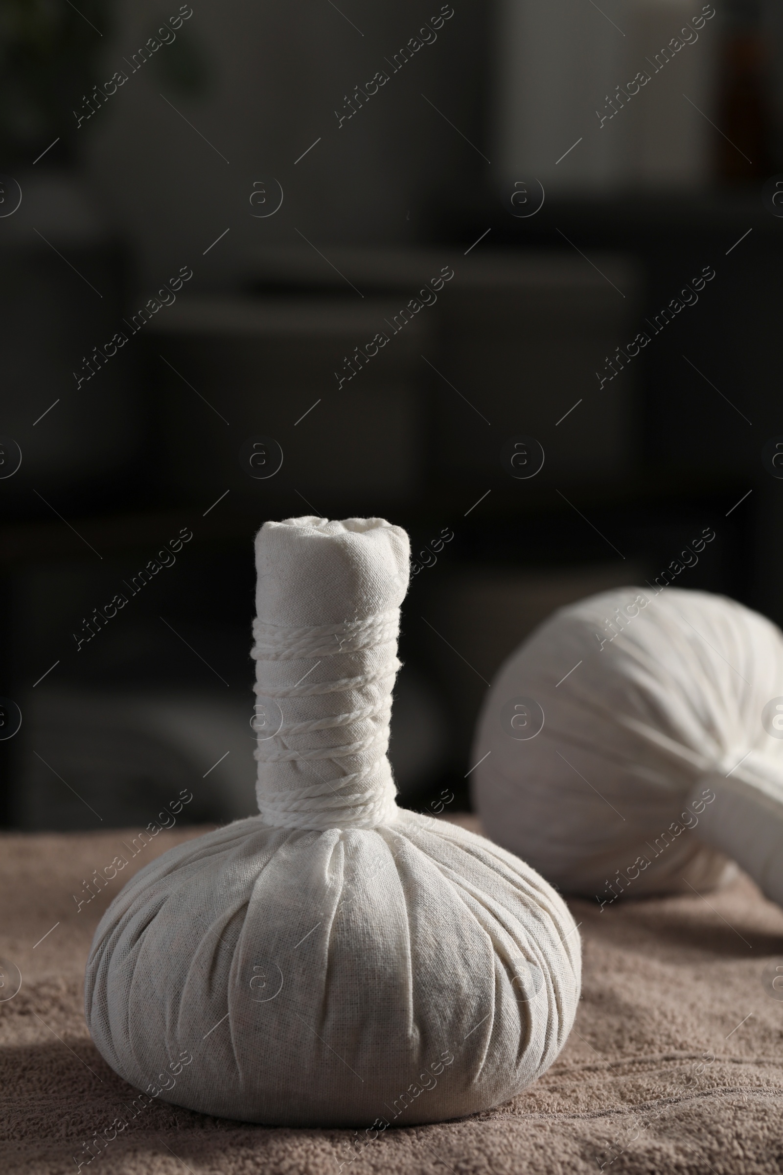 Photo of Herbal massage bags on bath towel indoors. Spa procedure