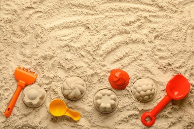 Photo of Flat lay of beach toy kit on sand, space for text. Outdoor play