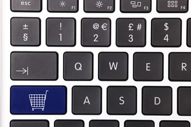 Image of Internet store. Blue button with shopping cart on computer keyboard, top view