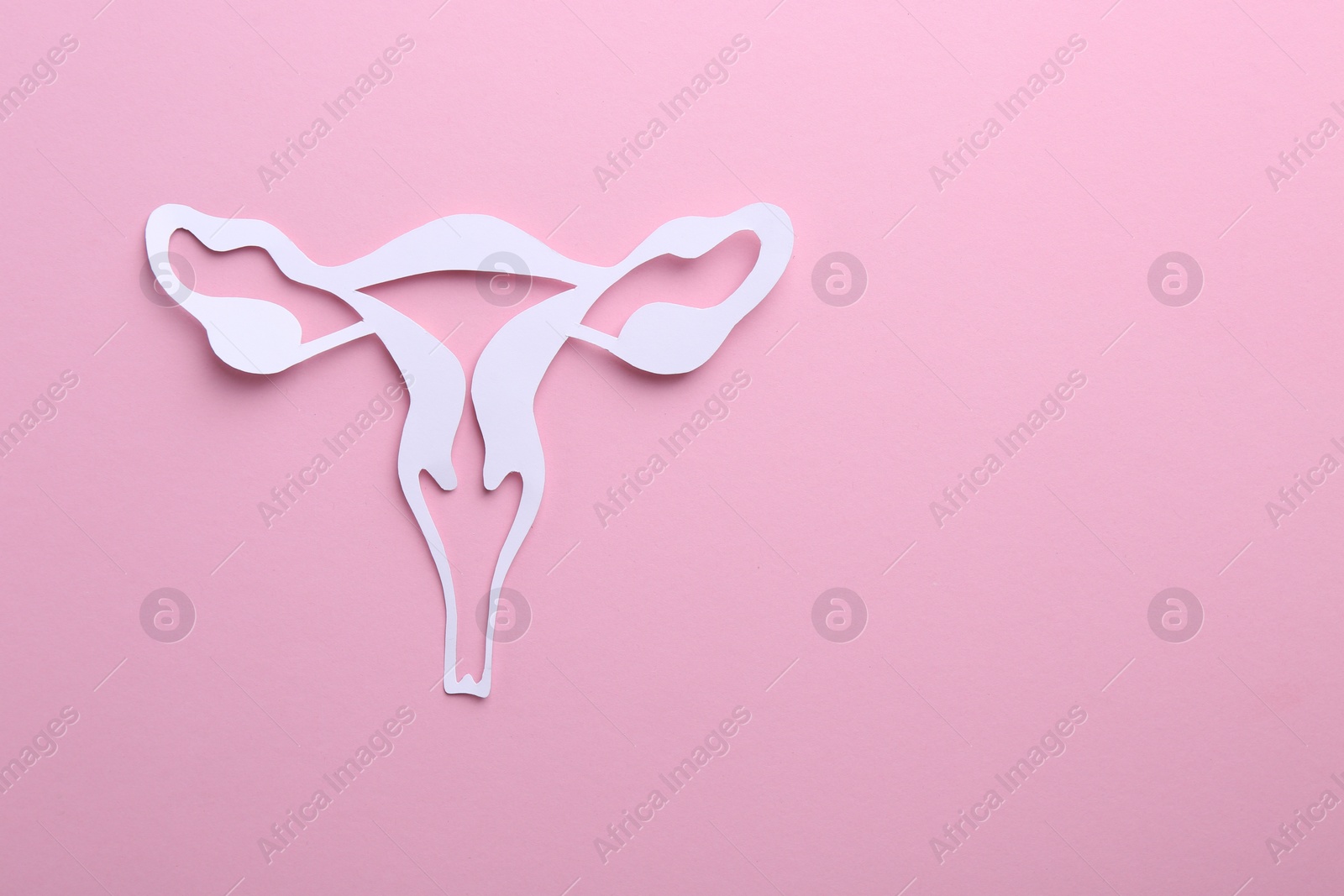 Photo of Reproductive medicine. Paper uterus on pink background, top view with space for text