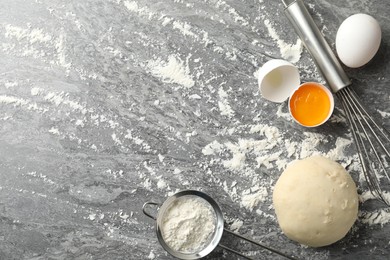 Photo of Flat lay composition with dough on grey table, space for text. Cooking pastries