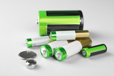 Different types of batteries on light background