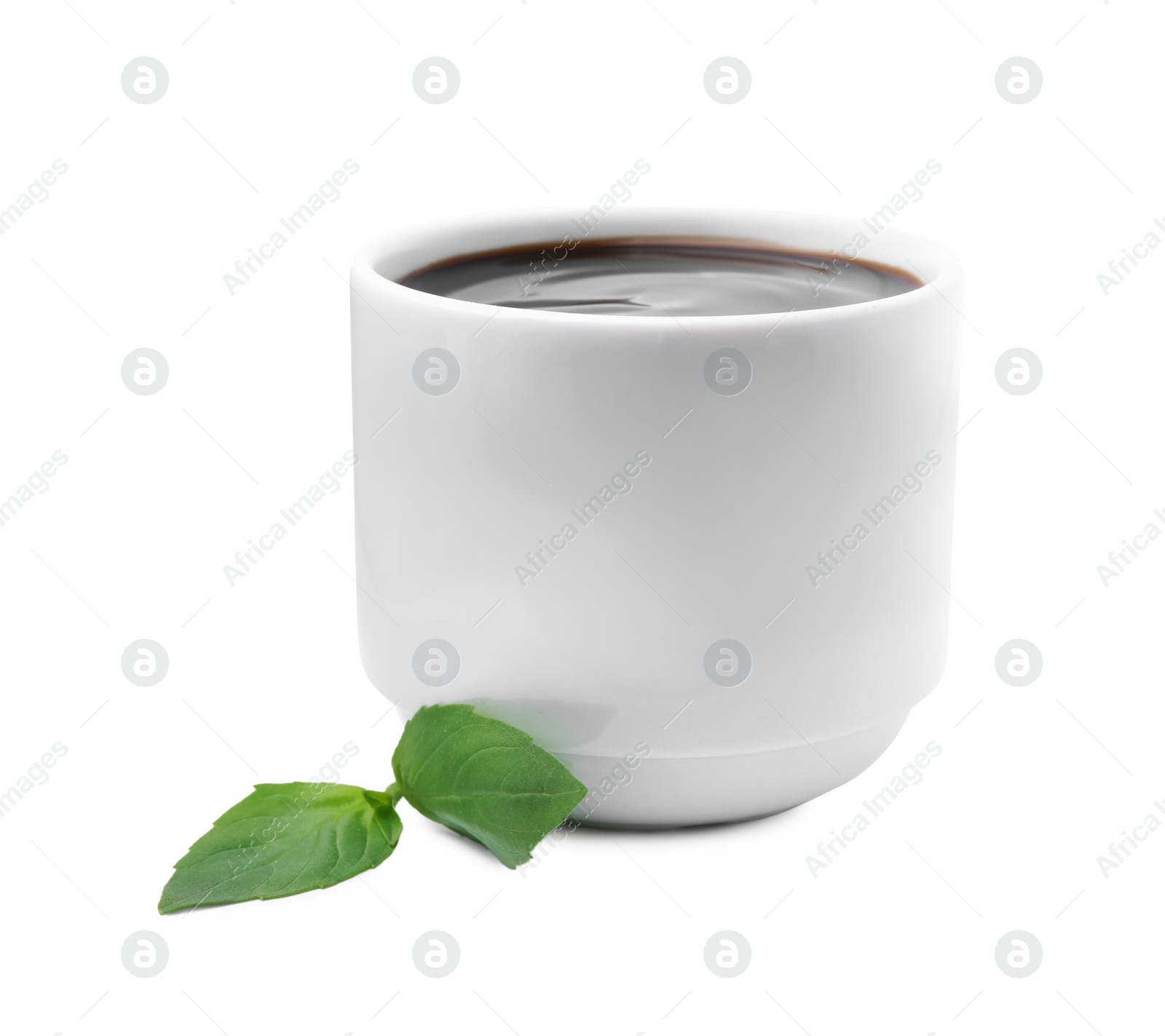 Photo of Balsamic glaze and basil leaves on white background