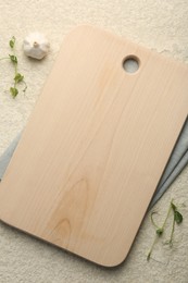 Photo of Wooden cutting board and napkin on beige table, flat lay. Space for text