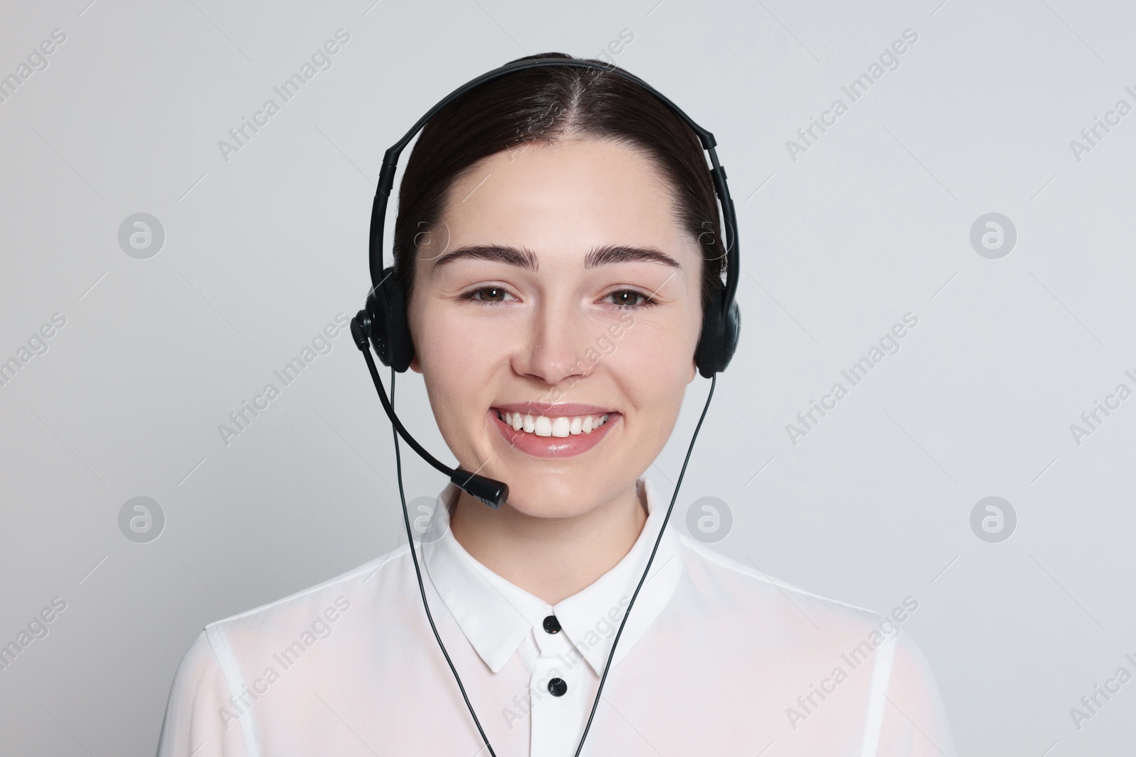 Photo of Hotline operator with modern headset on light grey background. Customer support