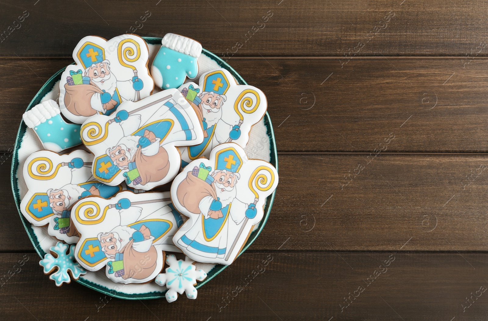 Photo of Tasty gingerbread cookies on wooden table, top view with space for text. St. Nicholas Day celebration