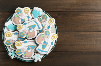 Photo of Tasty gingerbread cookies on wooden table, top view with space for text. St. Nicholas Day celebration