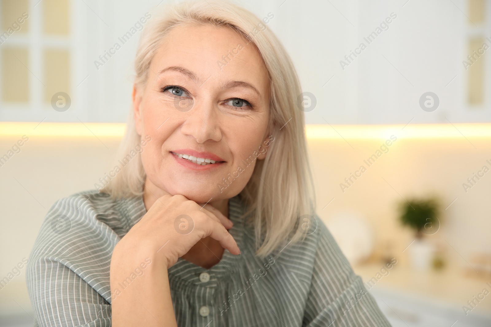 Photo of Portrait of beautiful mature woman in kitchen