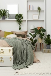 Photo of Stylish bedroom with comfortable bed and different houseplants. Interior design