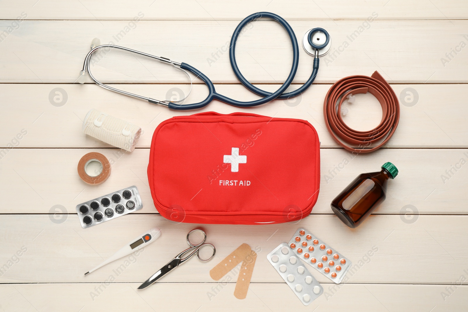 Photo of Flat lay composition with first aid kit on white wooden table