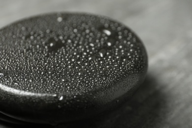 Wet black spa stone on grey table, closeup