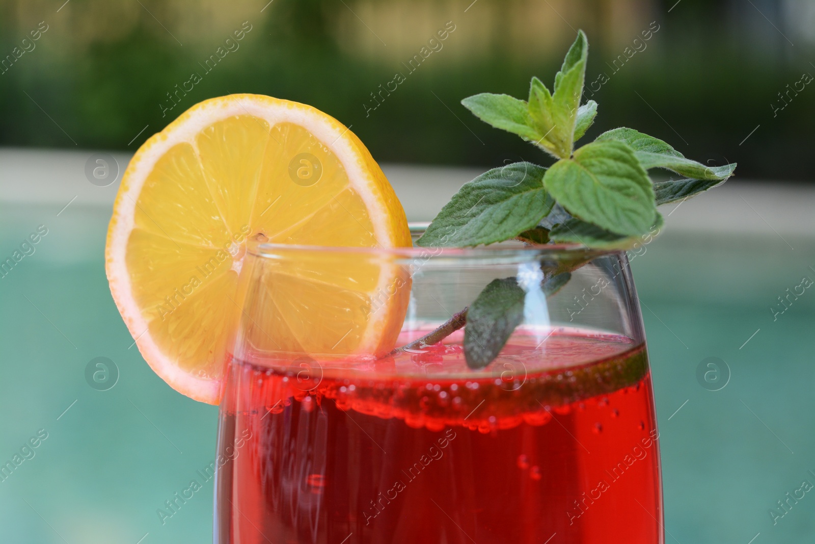 Photo of Glass of delicious cocktail on blurred background, closeup. Refreshing drink