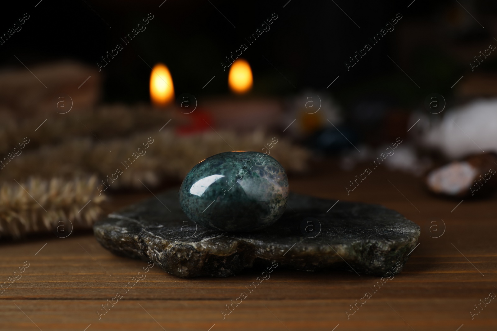 Photo of Healing gemstone on wooden table against blurred background