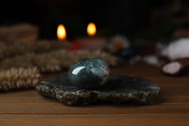 Photo of Healing gemstone on wooden table against blurred background