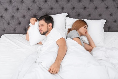 Couple with relationship problems in bed at home