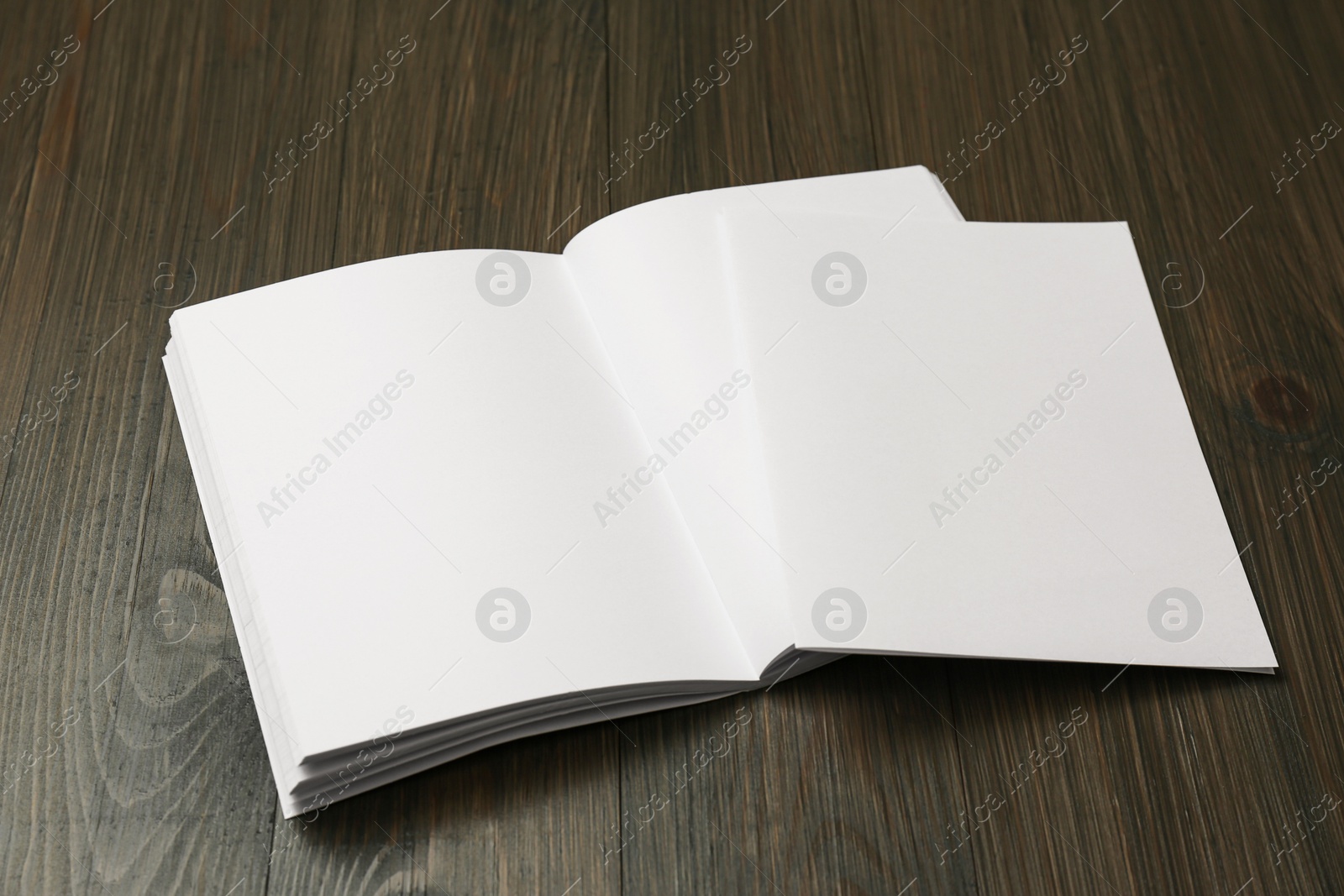 Photo of Sheet of paper and blank brochure on wooden table. Mockup for design