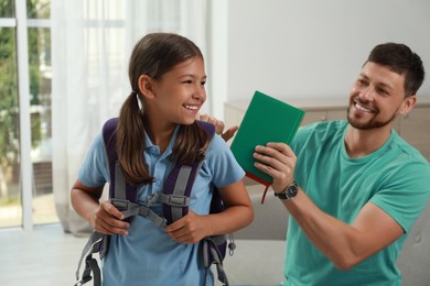 Father helping his daughter to get ready for school at home