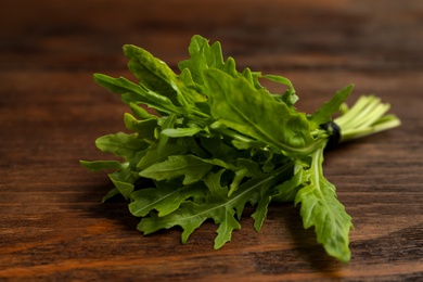 Bunch of fresh arugula on wooden table, closeup