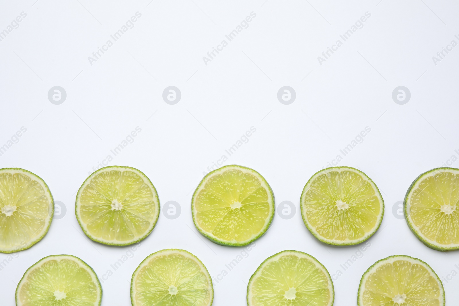 Photo of Fresh juicy lime slices on white background, top view