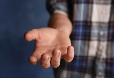 Photo of Woman offering helping hand on color background, closeup