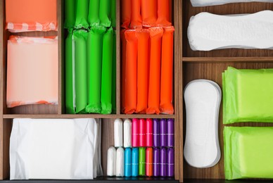 Photo of Storage of different feminine hygiene products in wooden organizers, top view