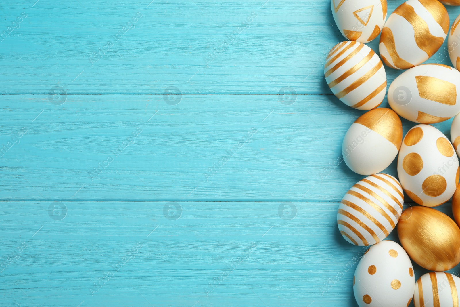 Photo of Traditional Easter eggs decorated with golden paint on wooden background, top view. Space for text