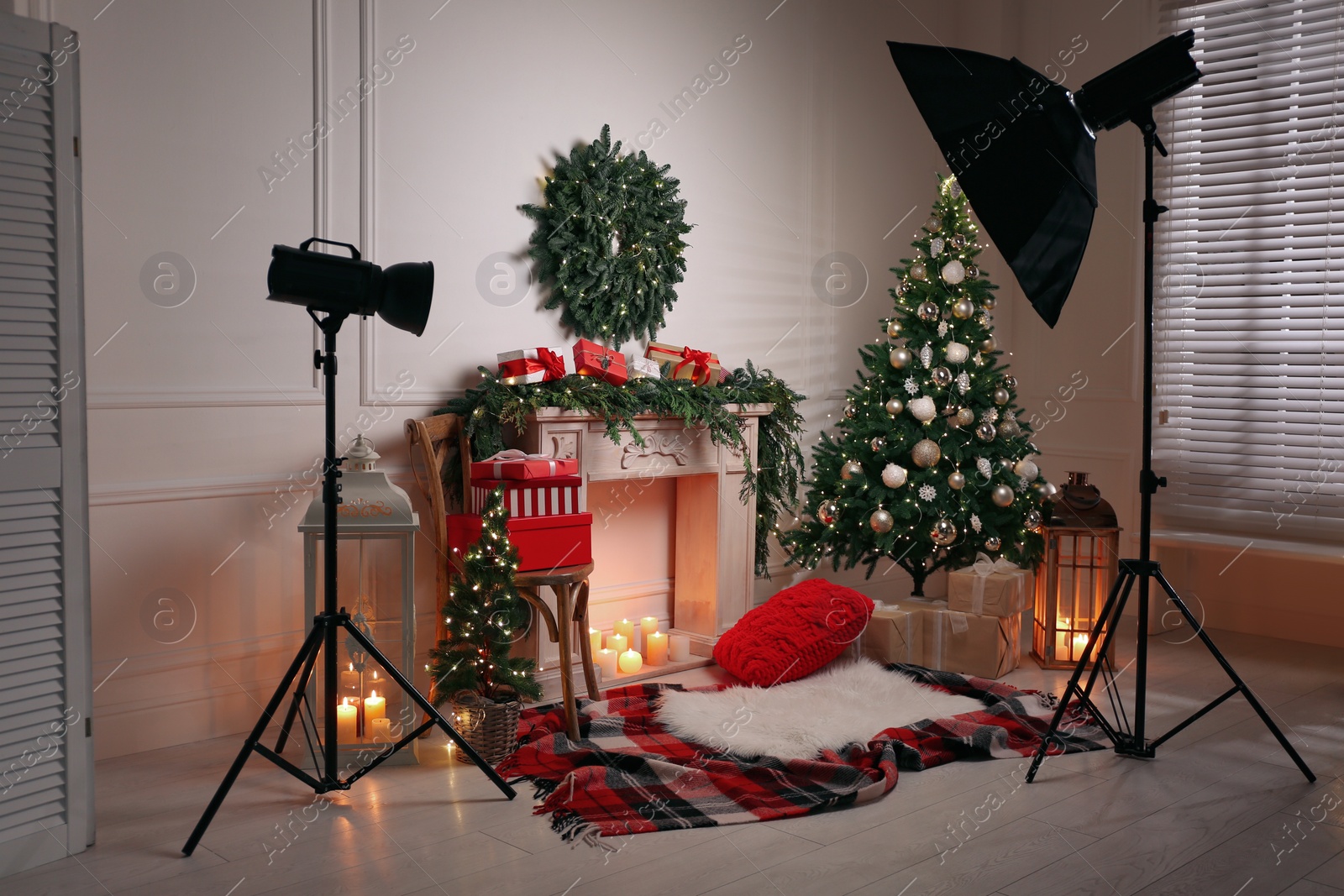 Photo of Beautiful Christmas themed photo zone with professional equipment and fireplace