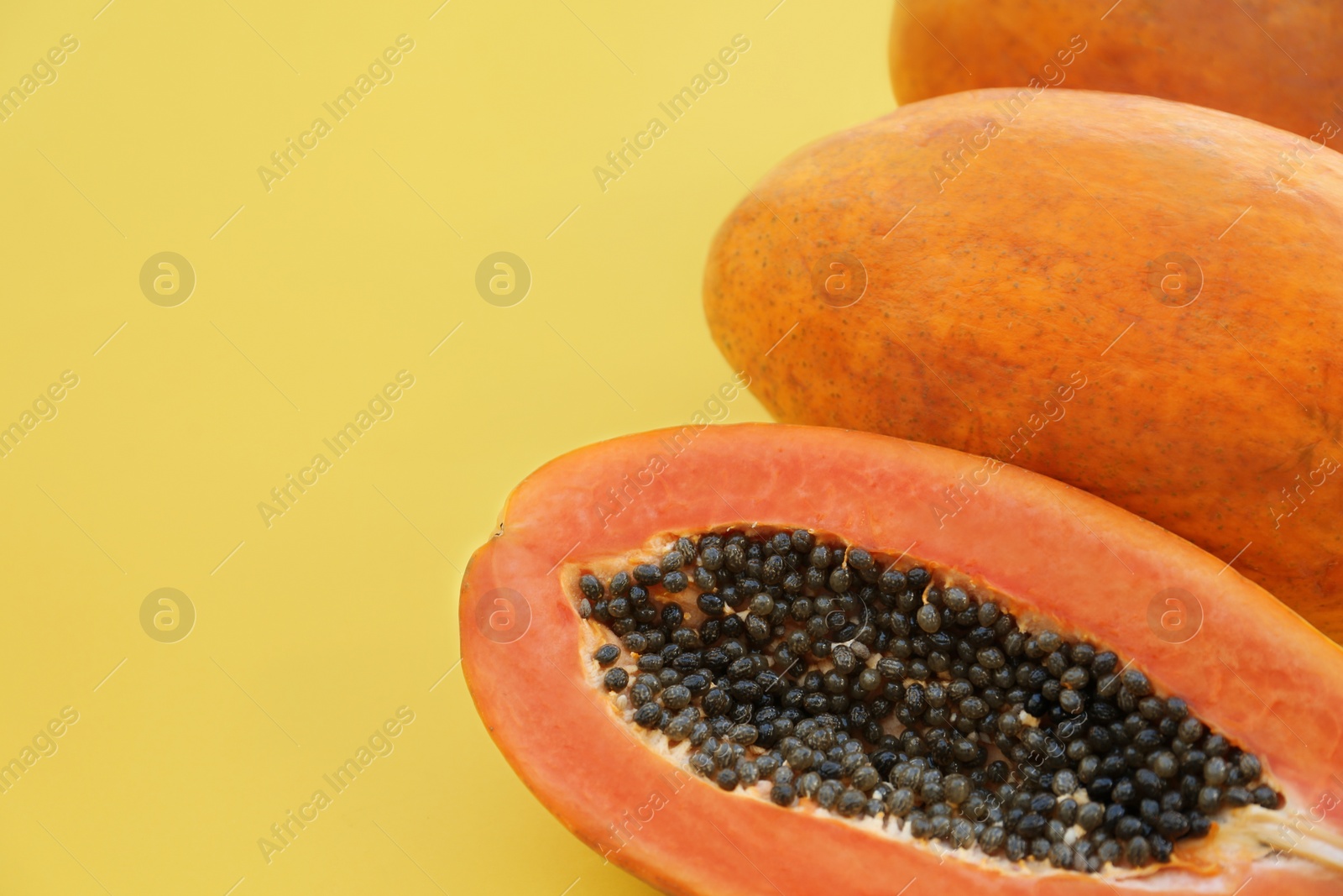 Photo of Fresh ripe cut and whole papaya fruits on light green background, flat lay. Space for text