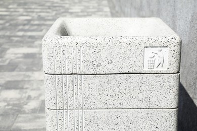 Photo of Modern grey trash bin outdoors, closeup view