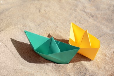Two color paper boats on sandy beach